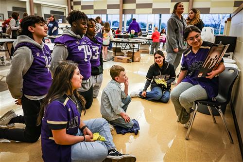 Students listen to another student read a book